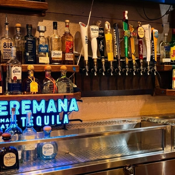 A well-stocked bar with various tequila bottles, beer taps, and a glowing "Teremana Tequila" sign.